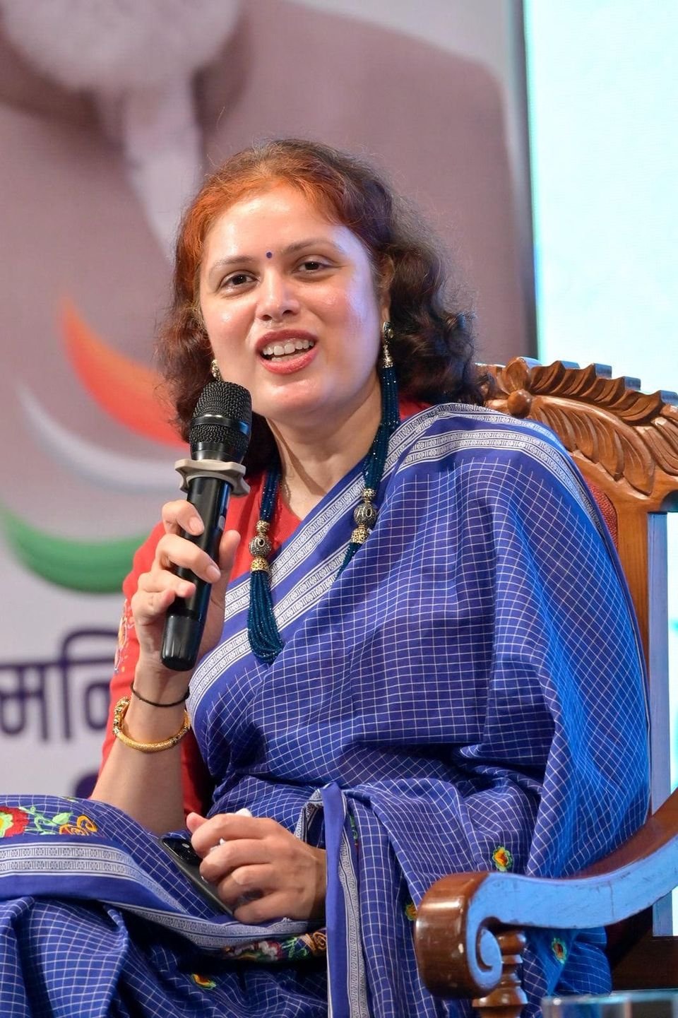 Pallavi Salgaocar speaking into a microphone at an industry event.